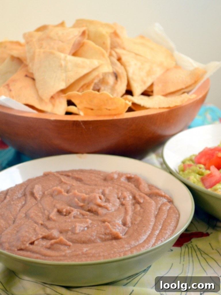 Serving Refried Beans and Guacamole Refried Beans and Guacamole served with a spoon and chips