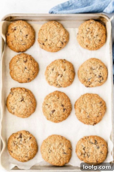 No-Butter Oatmeal Bliss 6 Five butterless oatmeal cookies stacked on a white plate, with a rustic spoon nearby.