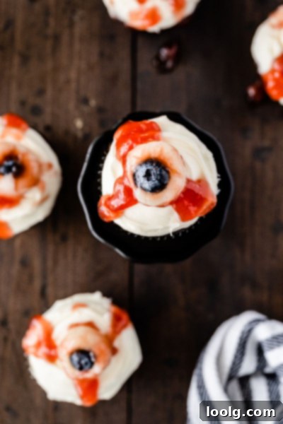 Ghoulish Gaze Cupcakes 2 Eyeball cupcakes for Halloween, featuring a moist chocolate base, cream cheese frosting, and a lychee-blueberry eyeball topped with strawberry jam blood.