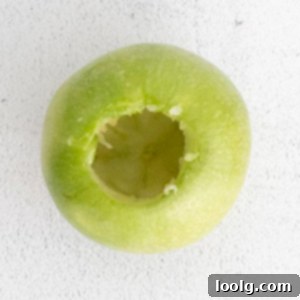 Quick & Easy Air Fryer Baked Apples 8 process photo showing a bright green apple that has been cored to make air fryer baked apples