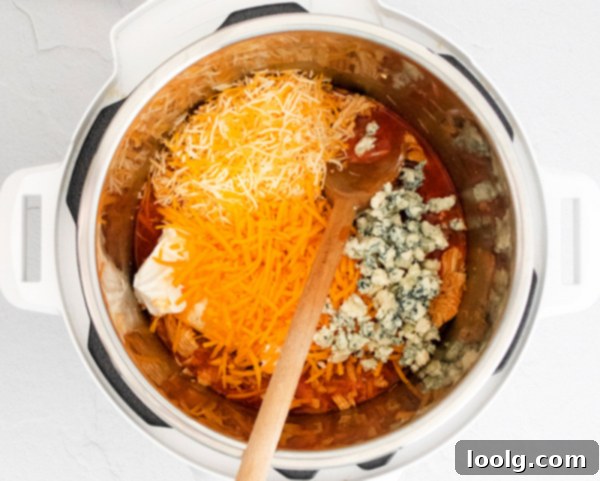 Ultimate Instant Pot Buffalo Chicken Dip 4 Close-up of Instant Pot Buffalo Chicken Dip ingredients ready to be cooked: hot sauce, butter, chicken, and ranch seasoning