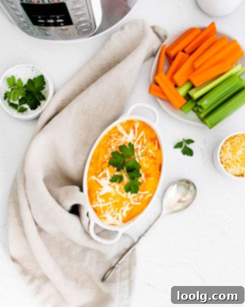 Ultimate Instant Pot Buffalo Chicken Dip 6 Instant Pot Buffalo Chicken Dip served in a white bowl with a side of fresh carrot sticks and celery stalks for dipping