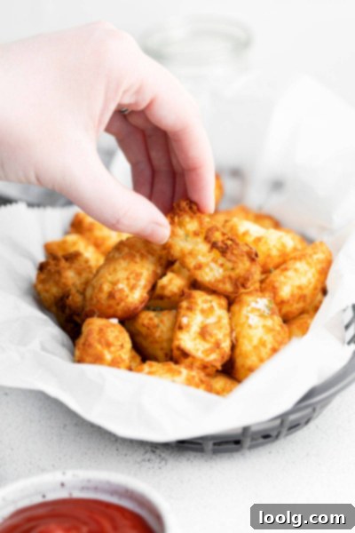 Crispy Air Fryer Tater Tots with Hash Brown Hack 2 hand picking up Air fryer tater tot