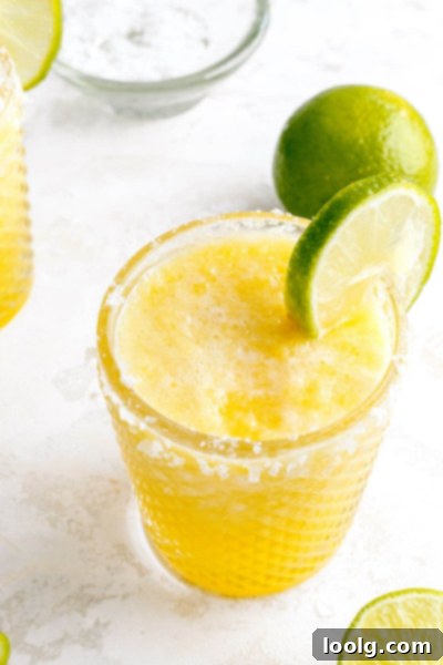 Easy 4-Ingredient Frozen Pineapple Margarita 7 frozen pineapple margarita with lime on glass