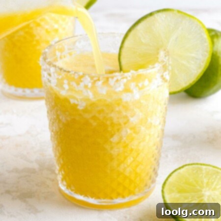 Easy 4-Ingredient Frozen Pineapple Margarita 8 pineapple margarita being poured in glass