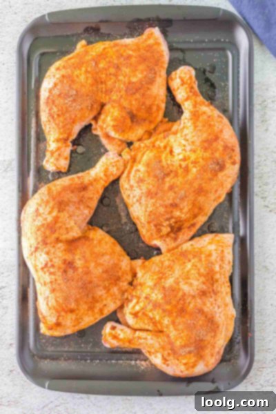 Perfectly Smoked Chicken Quarters 4 Chicken leg quarters coated in dry rub, ready to be placed on the smoker grates.