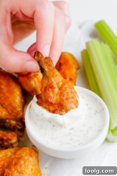 Frozen to Fabulous Air Fryer Chicken Wings 2 hand picking up air fryer frozen wings