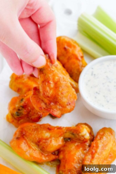 Frozen to Fabulous Air Fryer Chicken Wings 8 hand picking up air fryer wings