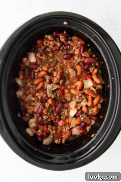 Venison Chili, Your Way: Slow Cooker or Stovetop 5 A close-up shot of raw ground venison, showing its lean, dark red color and finely ground texture. It's presented on a white plate, highlighting the quality of the meat before cooking. This image helps to visualize the main ingredient of the chili recipe.