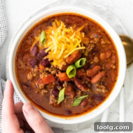 Venison Chili, Your Way: Slow Cooker or Stovetop 10 hand on bowl of venison chili
