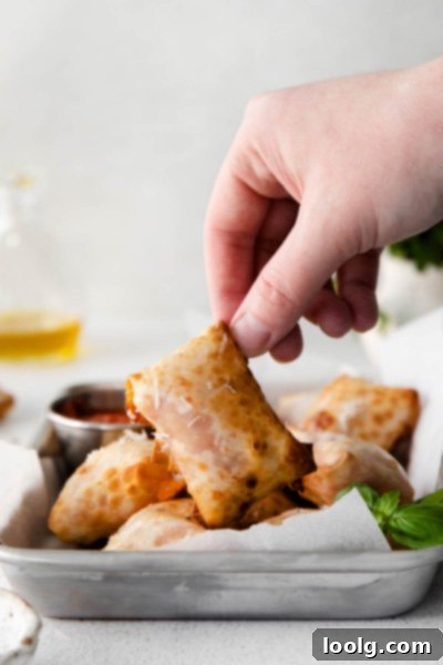 Crispy Air Fryer Pizza Bites 6 hand picking up air fryer pizza rolls