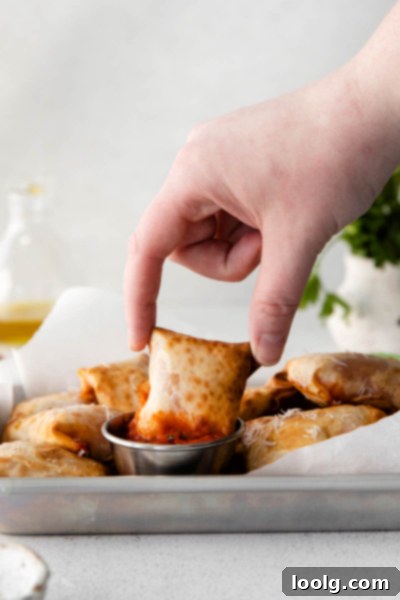 Crispy Air Fryer Pizza Bites 9 fingers picking up air fryer pizza rolls