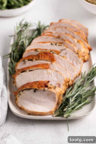 Perfect Air Fryer Turkey Breast 2 Air Fryer Turkey Breast sliced and garnished with fresh rosemary