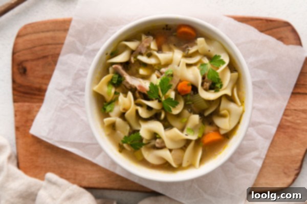 Cozy Instant Pot Turkey Noodle Soup 7 Several bowls of warm, comforting turkey noodle soup on a rustic wooden table
