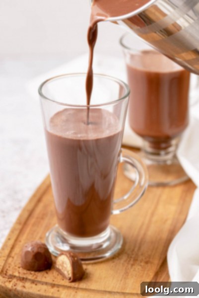 One-Pot Hot Chocolate Magic 4 Four glasses of Instant Pot Hot Chocolate are artfully arranged, each topped with a generous swirl of whipped cream and a sprinkle of cocoa. The focus is on the inviting texture and presentation of the drink.