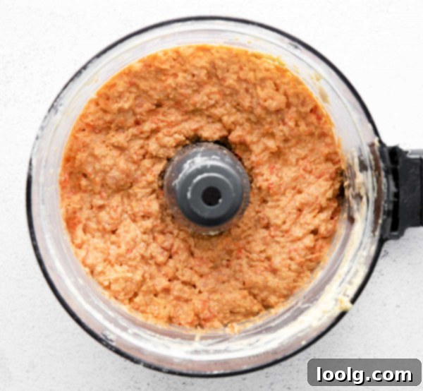 Smoky Red Pepper Hummus 3 Another image of roasted red pepper hummus in a bowl with a spoon