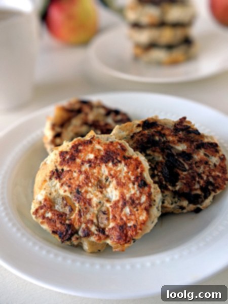 Sweet and Savory Chicken Apple Sausage 4 Cooked chicken apple sausage patties arranged on a plate with fresh sage garnish.
