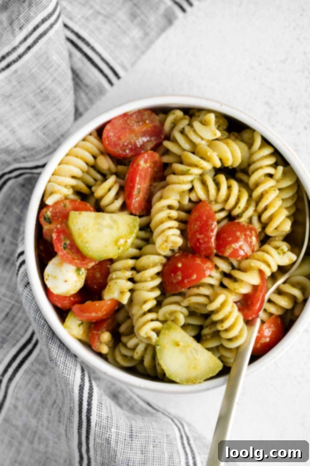 Refreshing Summer Pesto Pasta Salad 2 spoon on bowl of pasta salad