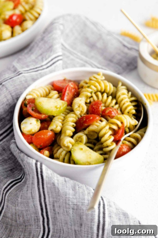 Refreshing Summer Pesto Pasta Salad 5 spoon in a bowl of summer pesto pasta salad