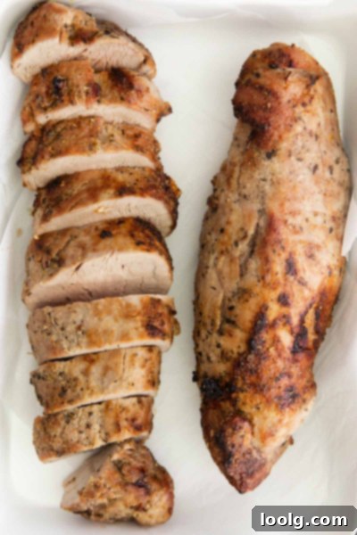 Perfect Air Fryer Pork Tenderloin 5 Air Fryer Pork Tenderloin on a cutting board, ready to be sliced