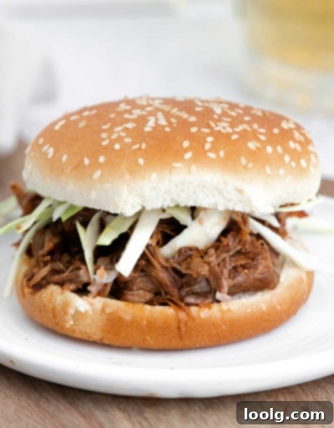 Fall-Apart Instant Pot Pork Shoulder 2 image of an instant pot pork shoulder with shredded pork and sauce on a hamburger bun
