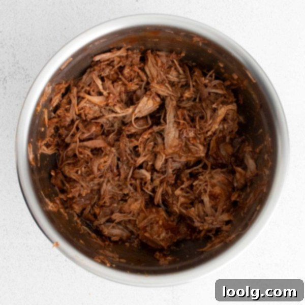 Fall-Apart Instant Pot Pork Shoulder 7 image of an instant pot pork shoulder being shredded by forks