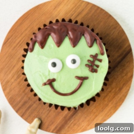 Frankenstein cupcake on a round wooden cutting board