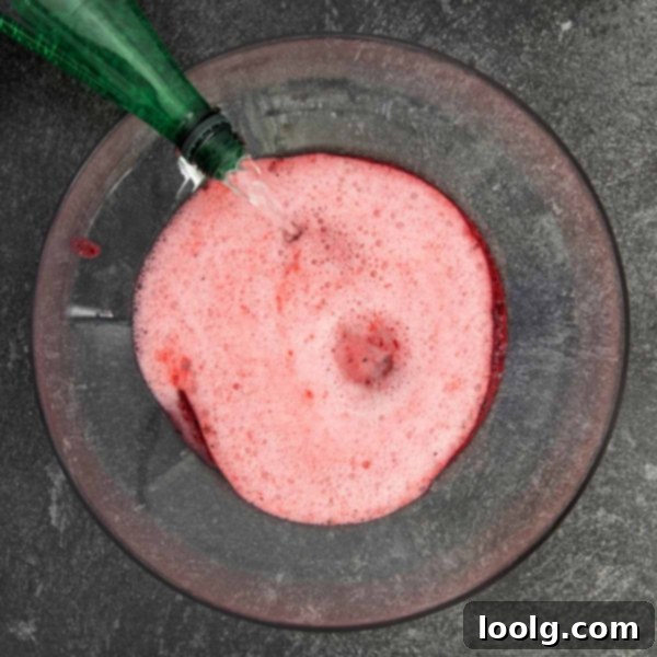 Fright Night Fizz 6 A festive punch bowl with non-alcoholic Halloween punch, emitting a spooky fog from dry ice, ready for a party.