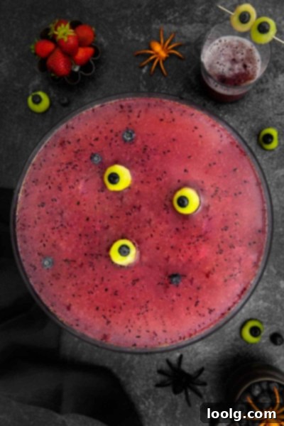 Fright Night Fizz 8 Non-alcoholic Halloween punch with melon eyeballs served in individual shot glasses, arranged in a punch bowl with dry ice for a smoky effect.