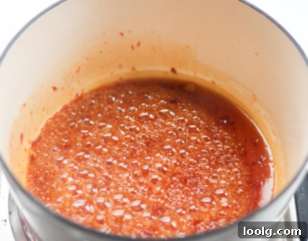 Baked or Air Fried Honey Garlic Wings 7 Crispy chicken wing being dipped into a small bowl of honey garlic sauce, ready to be eaten