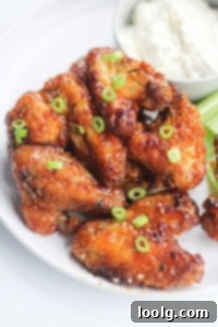 Your Air Fryer Game Day Playbook 5 Stacked honey garlic chicken wings cooked to perfection, golden brown and garnished with slivers of green onions
