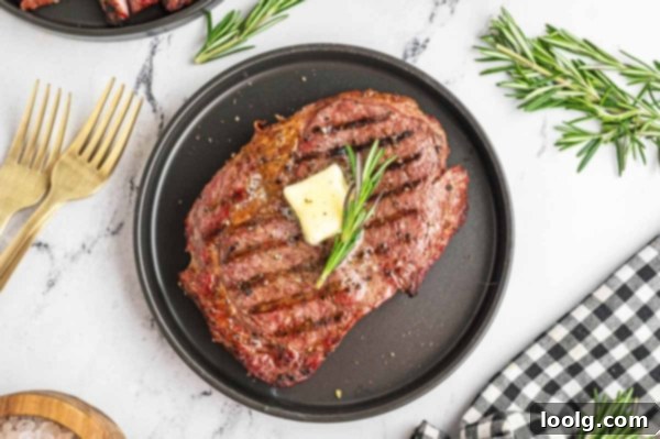 Ultimate Smoked Ribeye 11 A rustic cutting board with a knife and a sprig of rosemary, hinting at the delicious meal just enjoyed or about to be served.
