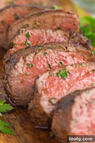 Prime Venison Loin 2 Perfectly cooked venison backstrap resting on a cutting board, ready to be sliced and served, showcasing its beautiful sear and juicy interior.