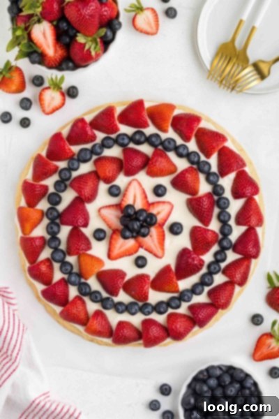 Patriotic Fruit Pizza 2 4th of July Fruit Pizza decorated with strawberries and blueberries in a patriotic pattern