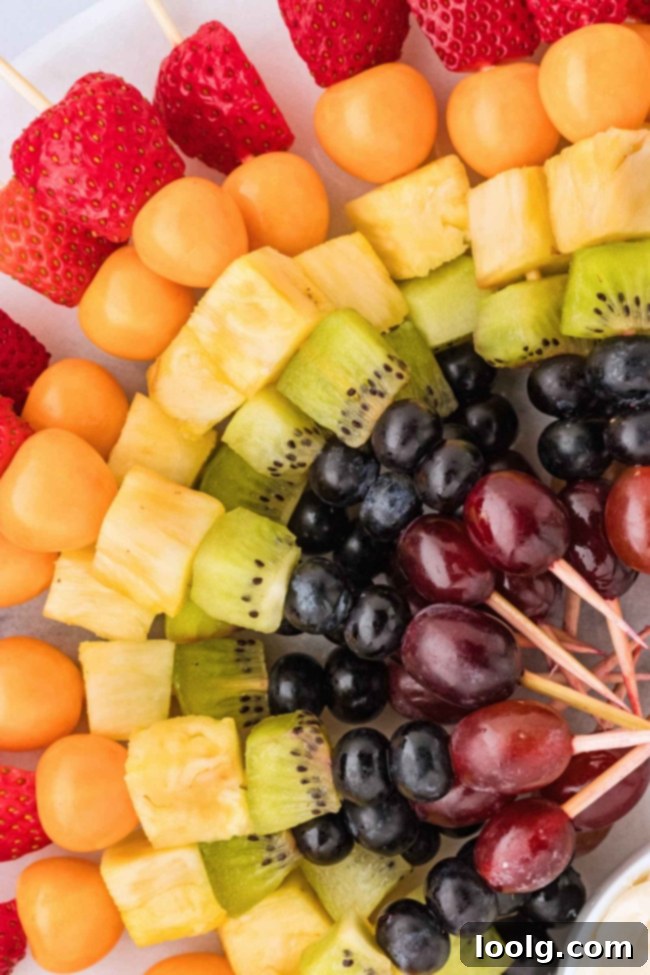 Rainbow Fruit Pops 5 Another perspective of the rainbow fruit skewers on a white serving tray, emphasizing the neat arrangement and colorful selection.