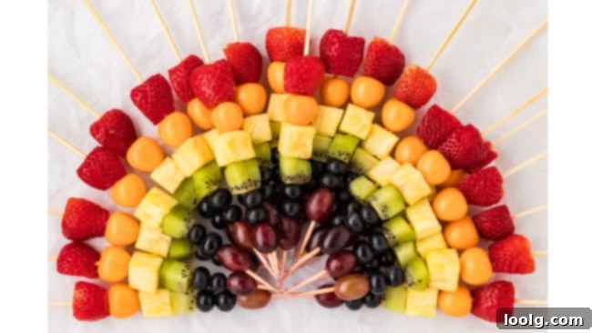 Rainbow Fruit Pops 10 A final close-up shot of several rainbow fruit skewers, beautifully arranged with the creamy dip, inviting a taste.