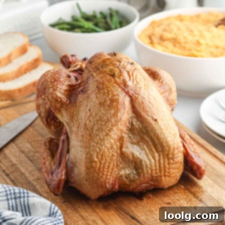 Traeger's Signature Smoked Turkey 11 Photo of a fully-cooked Traeger smoked turkey on a wooden cutting board with a bowl of green beans in the background.