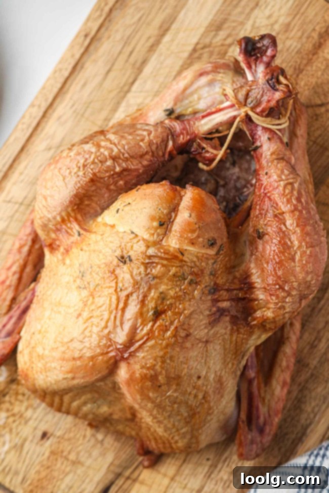 Traeger's Signature Smoked Turkey 5 The process of preparing a turkey, showing a person applying the herb butter under the skin.