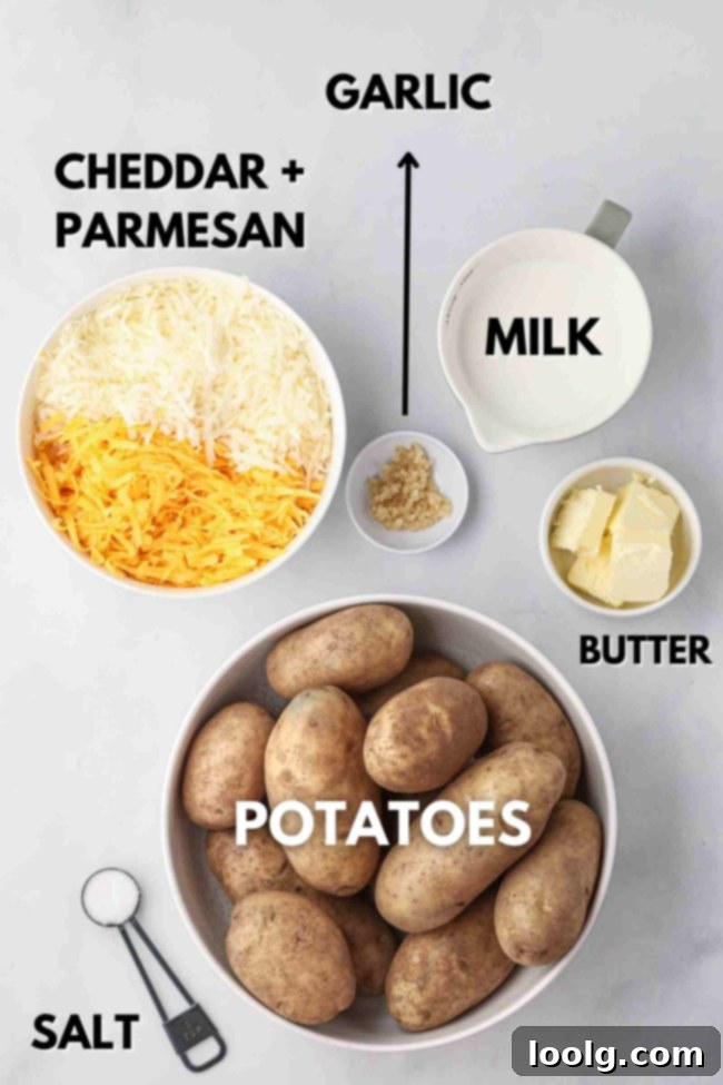 Creamy Cheesy Mashed Potatoes 4 An overhead shot showing the ingredients laid out: a bowl of peeled and cubed potatoes, a block of cheddar cheese, a block of Parmesan, a stick of butter, and a container of milk.