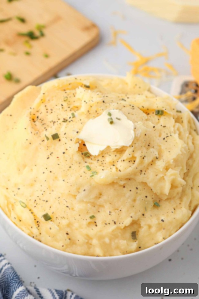 Creamy Cheesy Mashed Potatoes 9 A beautifully presented meal with a generous serving of cheesy mashed potatoes, a side of smoked turkey, and some green blanched broccoli, showcasing a complete and appealing dish.