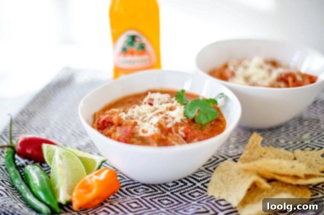 Qdoba's Signature Tortilla Soup 4 A bowl of Qdoba Tortilla Soup with a spoon, showing the rich texture.