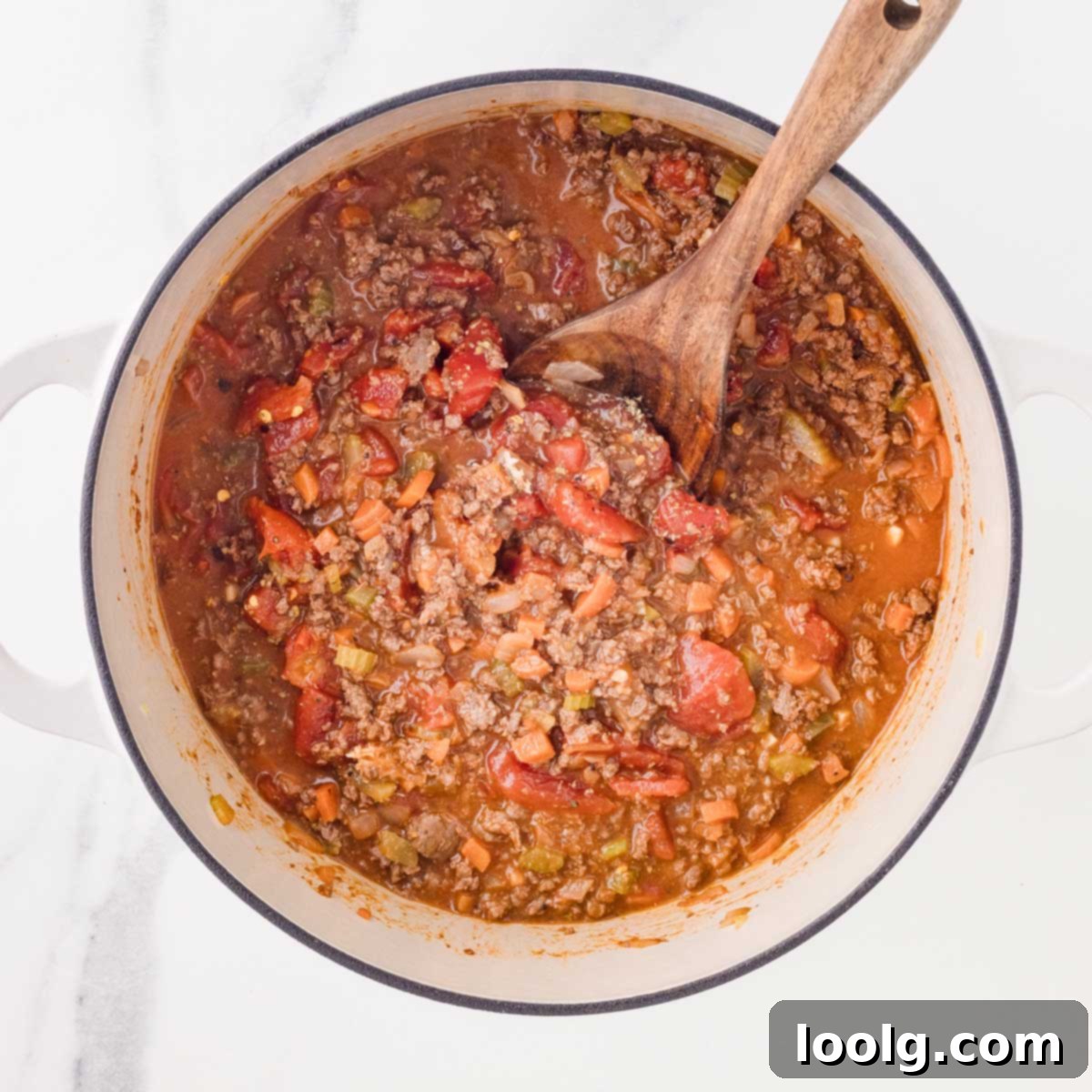 Slow-Simmered Venison Bolognese 11 wooden spoon in a pot of almost finished venison bolognese