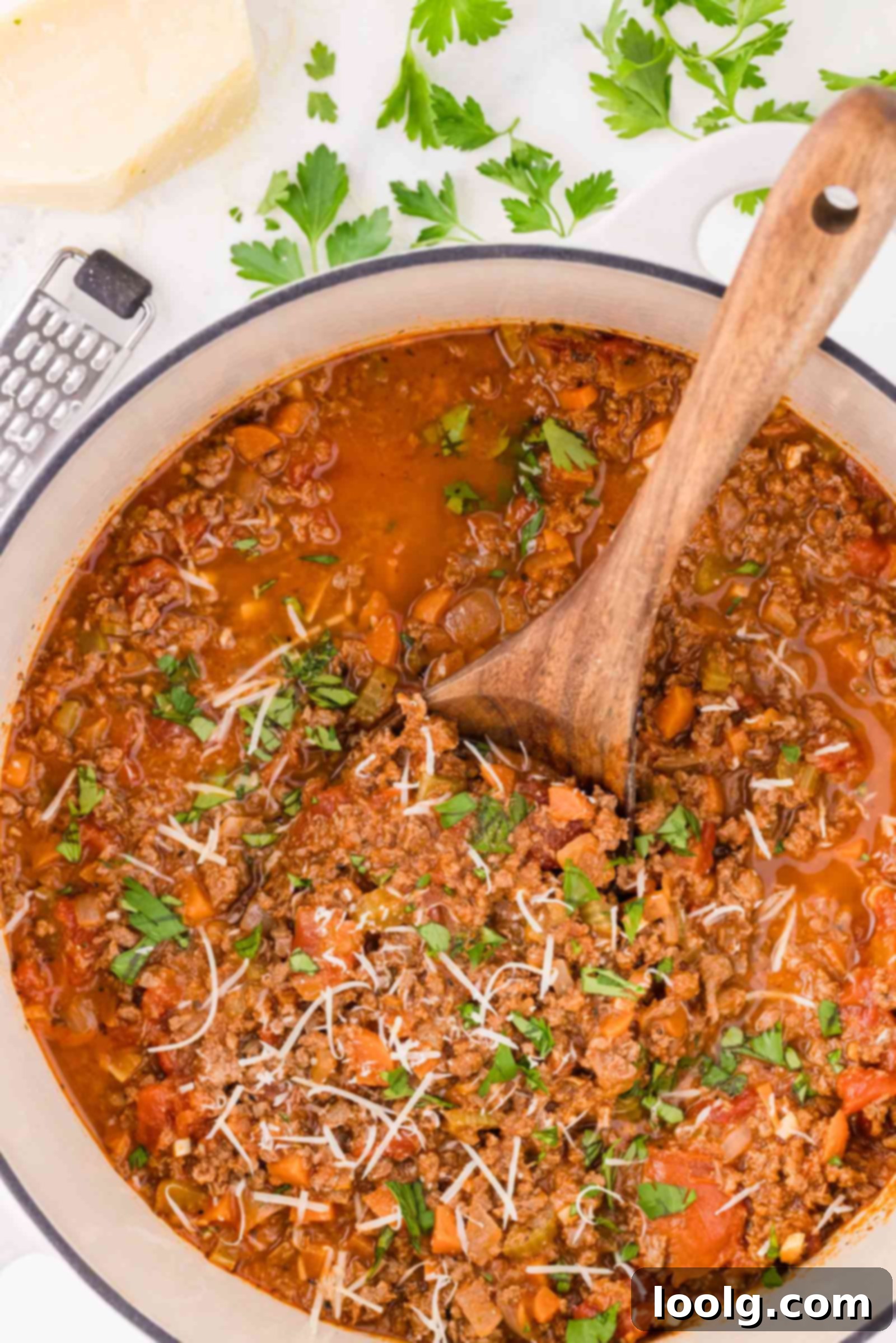 Slow-Simmered Venison Bolognese 3 a wooden spoon in a pot full of venison spaghetti