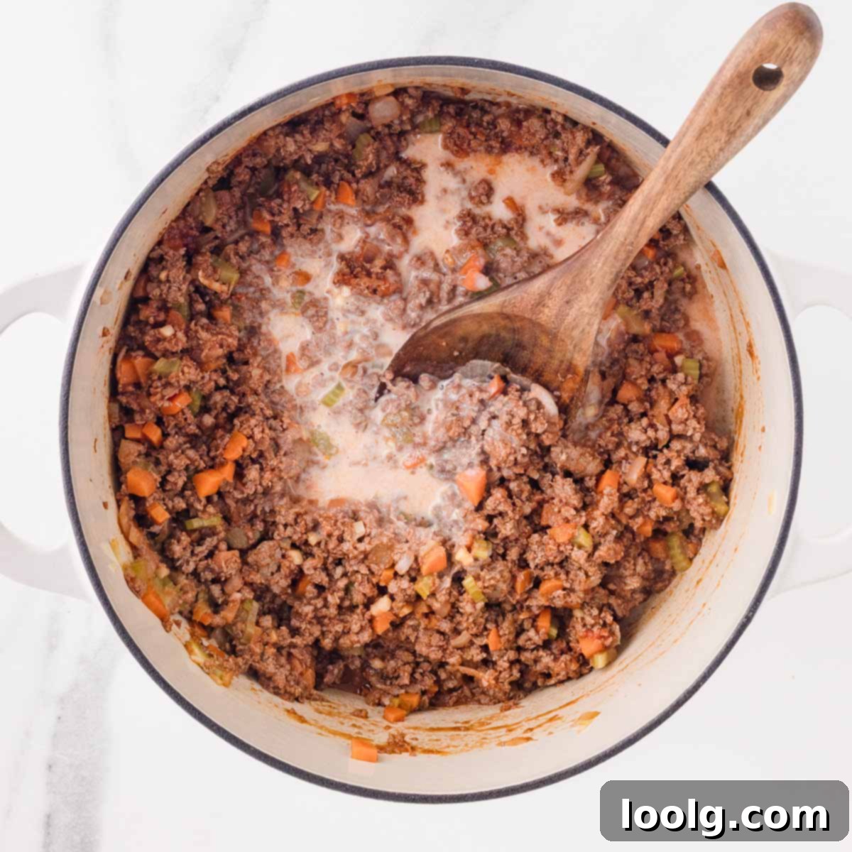 Slow-Simmered Venison Bolognese 9 adding milk to pot of deer bolognese