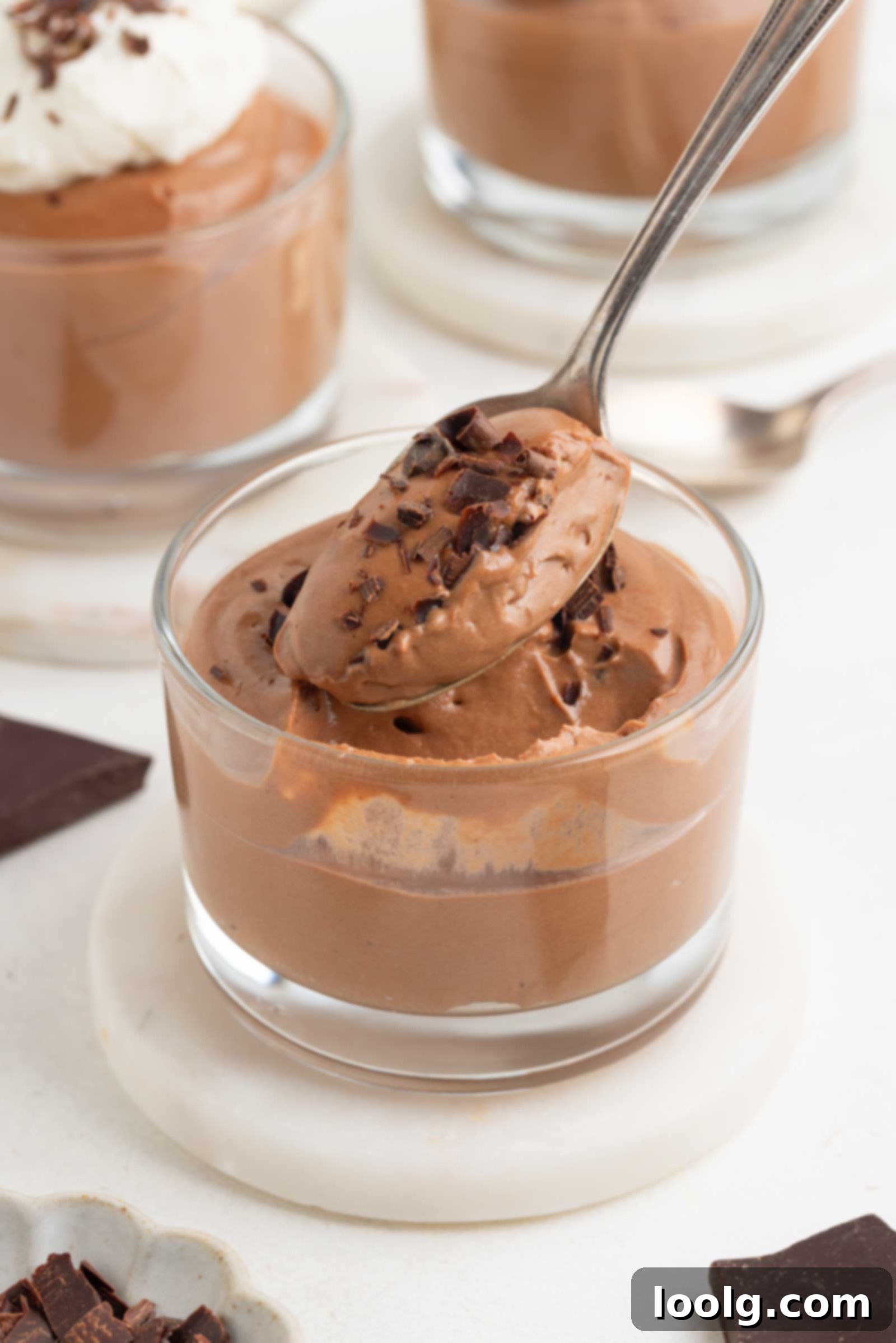 Velvet Chocolate Cheesecake Mousse 5 spoon digging into a glass of chocolate cheesecake mousse