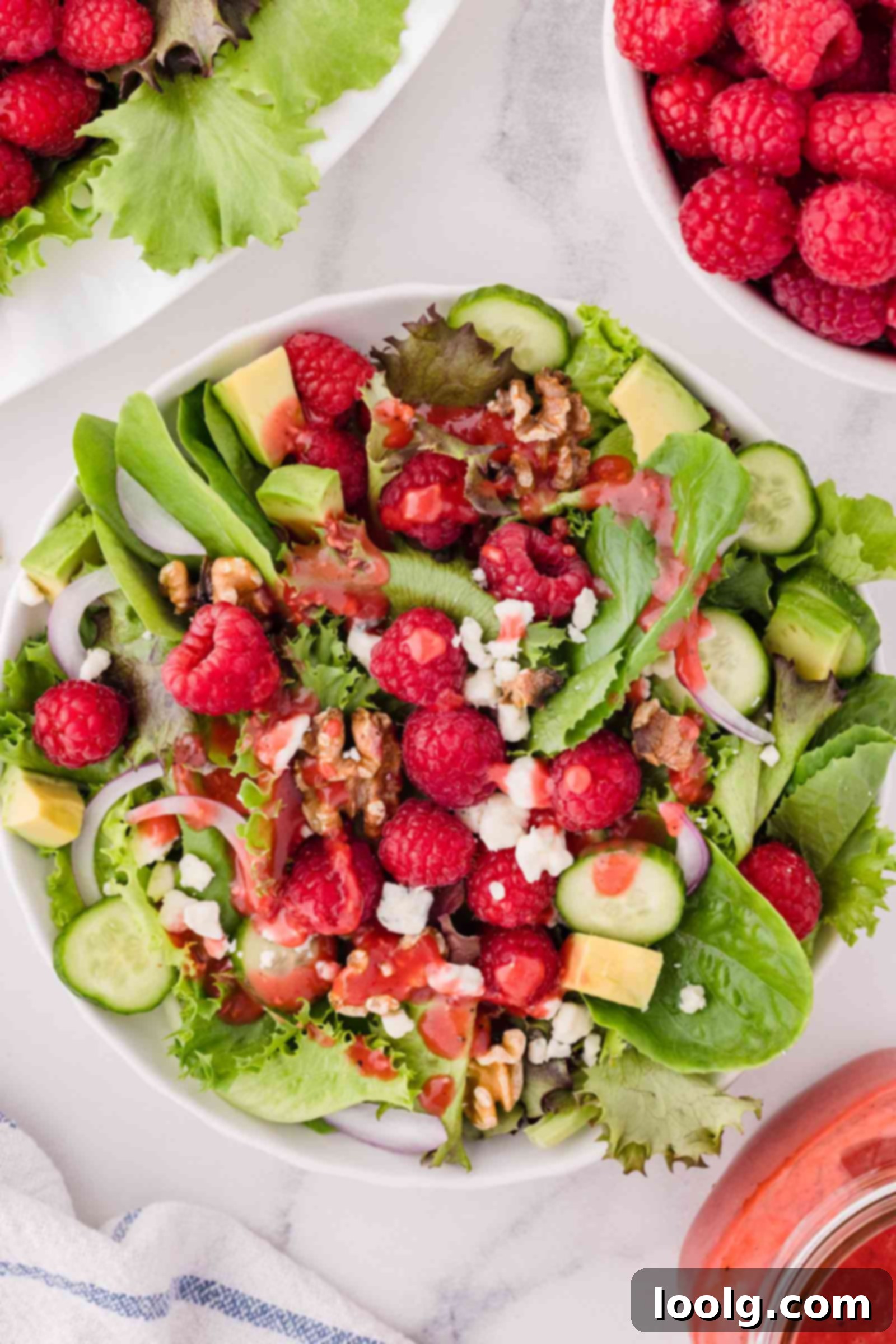 Refreshing Raspberry Salad 2 raspberry salad on a white plate with raspberries in background