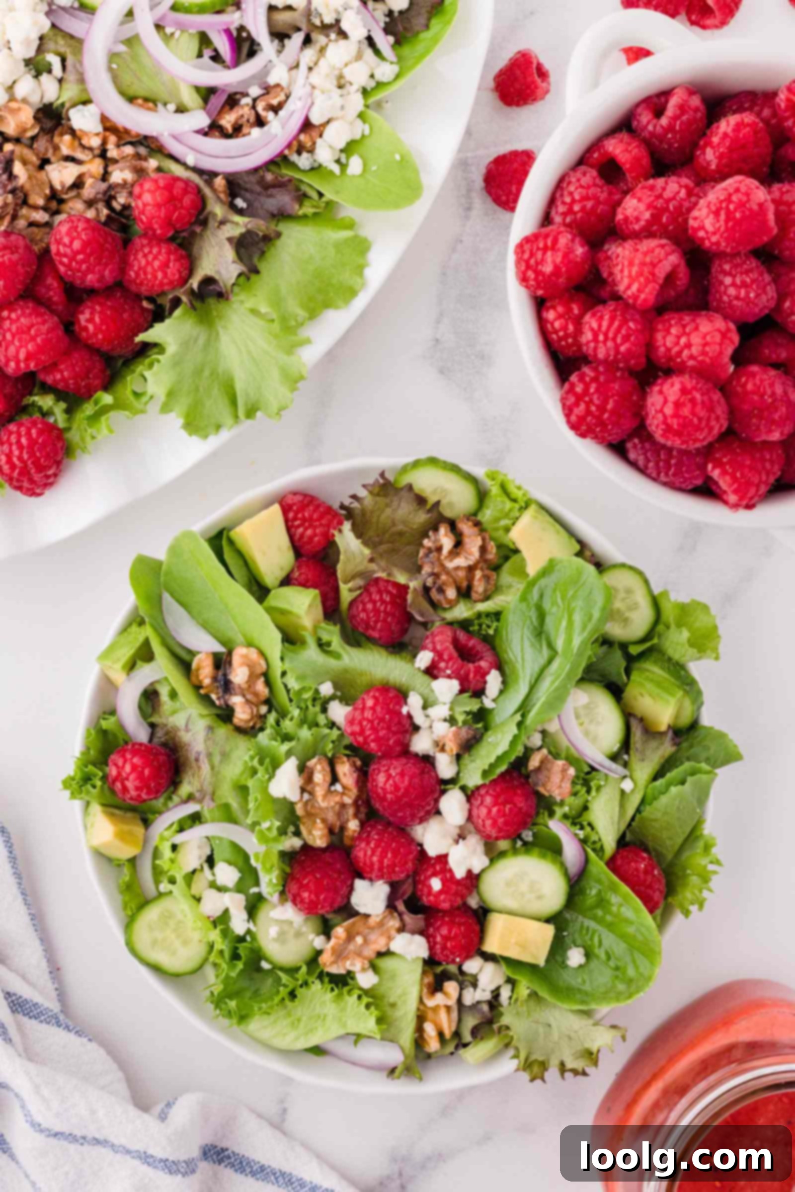 Refreshing Raspberry Salad 4 raspberry salad on a white plate with bowl of berries in background