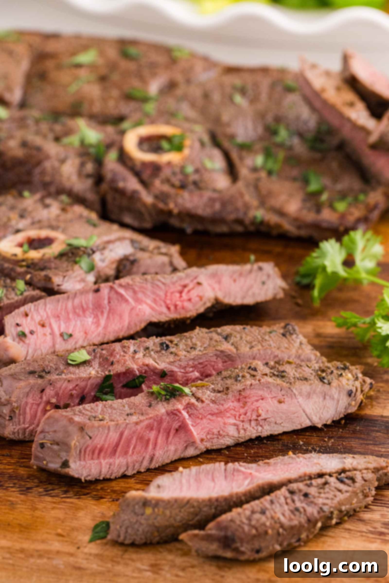 Signature Venison Steaks 2 sliced venison steaks on a wooden cutting board