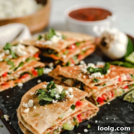 Effortless Plant-Based Quesadillas 6 A stack of freshly made vegetarian quesadillas with a side of salsa and sour cream.
