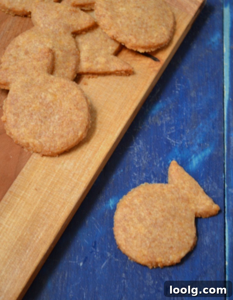 Baked Goldfish Crackers Various sizes of homemade goldfish crackers cooling on a baking sheet, showcasing their golden-brown hue.